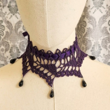 Pinwheel shaped lace collar. Each tip of the pinwheel ends in a teardrop bead.