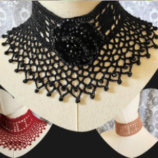 Black crocheted collar has filet panel around the neck with a lace flounce with faceted beads. At the throat is a crocheted rose with lots of faceted beads.