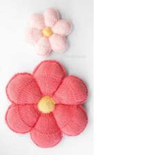 Knitted daisy style flower pillows with contrasting center. Two sizes each have six puffy petals.