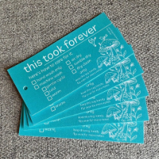 Teal cards with white lettering that says This took forever, along with checkboxes for laundering instructions and a cute line drawing of a forest mushroom.