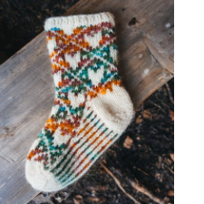 Colorwork socks with diamond design. In each diamond is a heart. Show in cream and a bright variegated yarn.