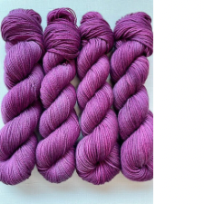 Twisted hanks of semi-solid yarn in red-violet.