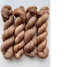 Twisted hanks of semi-solid yarn in warm camel brown.