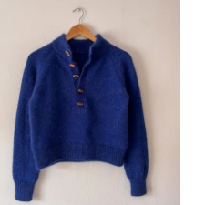 Bright blue relaxed raglan sweater with a distinctive button-up neckline and a high collar worked in 1 by 1 rib.