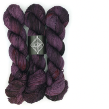 Three hanks of variegated yarn in muted red-violet and brown, with small splashes of red.